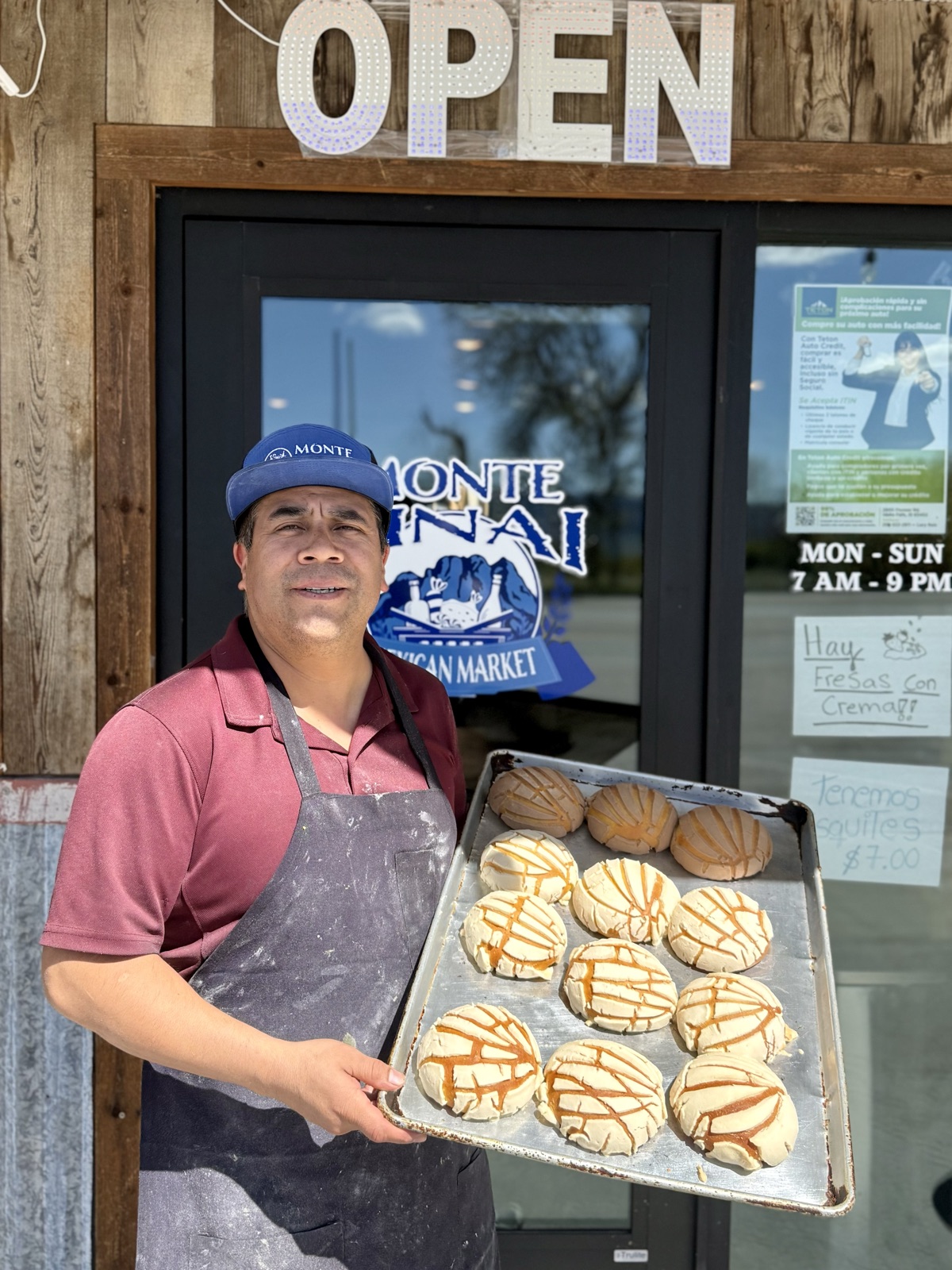 The owner of Monte Sinai holding a fresh tray of pan dulce outside the store