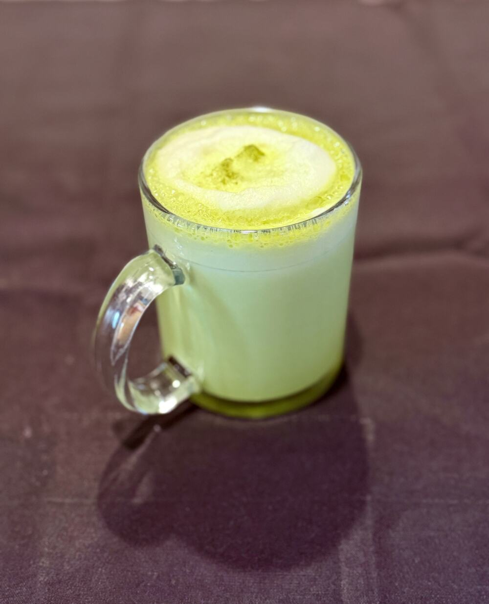 A matcha latte in a glass mug at Pampano's Cafe